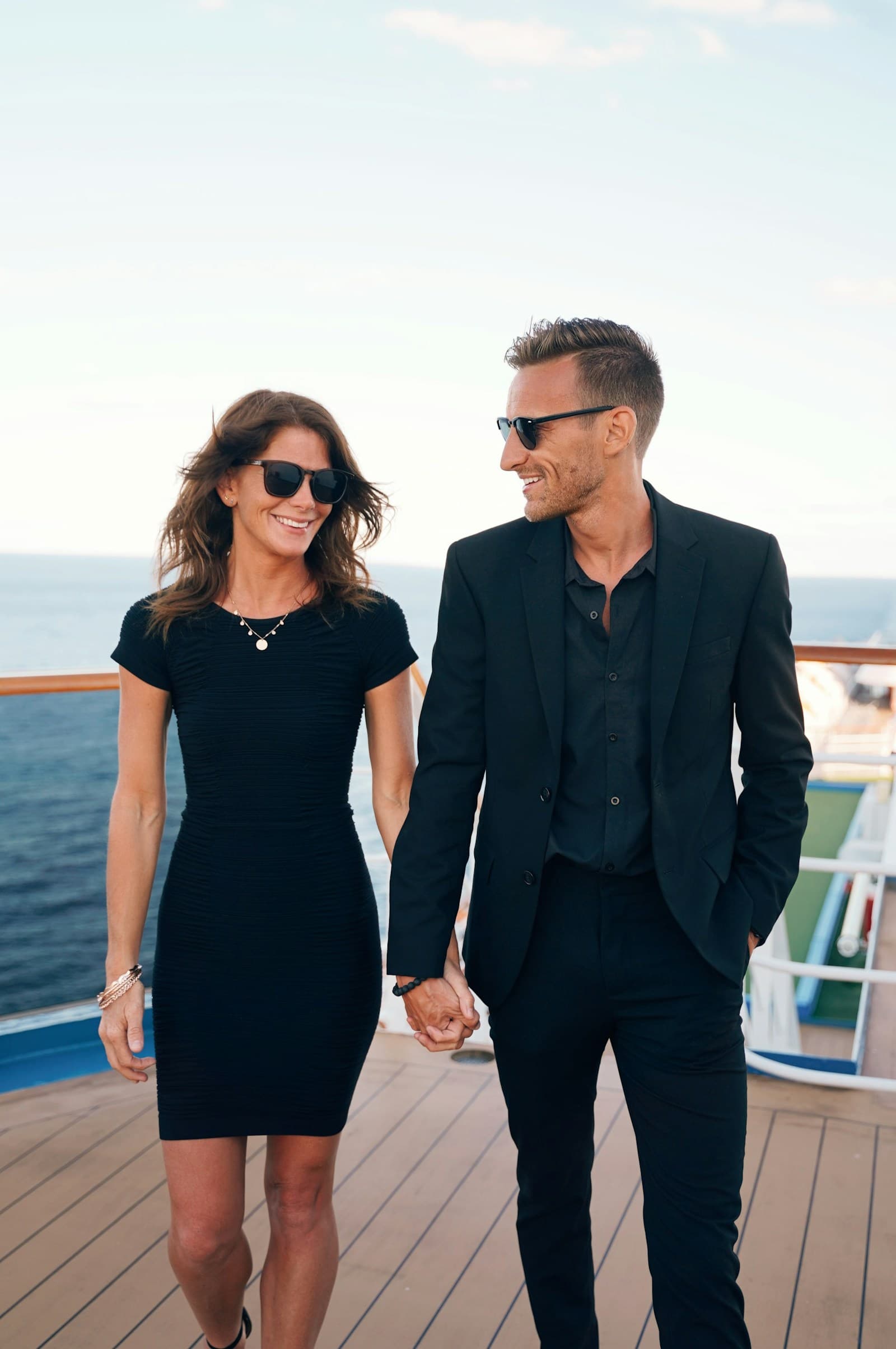 A smiling couple walking on a ship's deck off The Bahamas