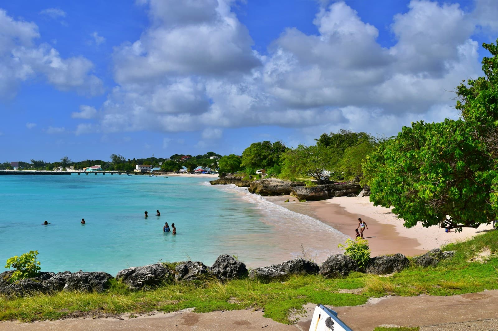 People swimming and walking along a Barbados beach