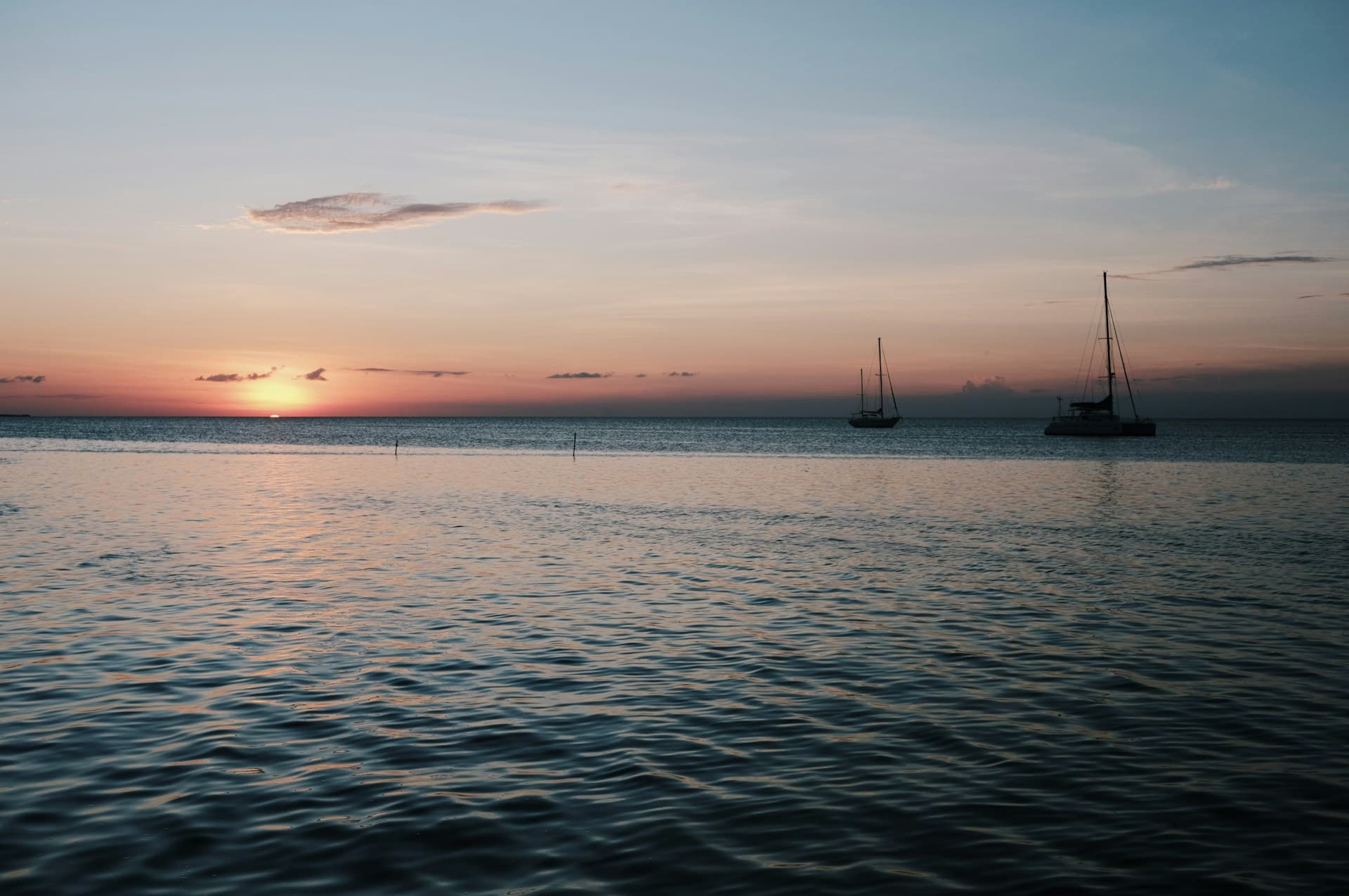 Sunset over the water with sailboats in Caye Caulker, Belize