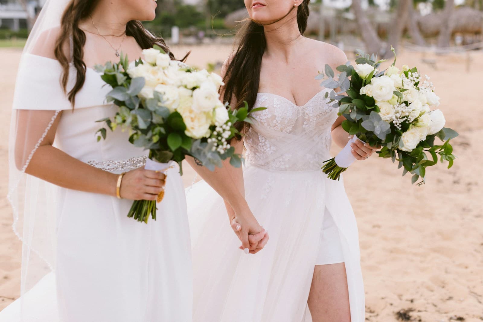 Two smiling brides walking on a beach in Punta Cana, Dominican Republic