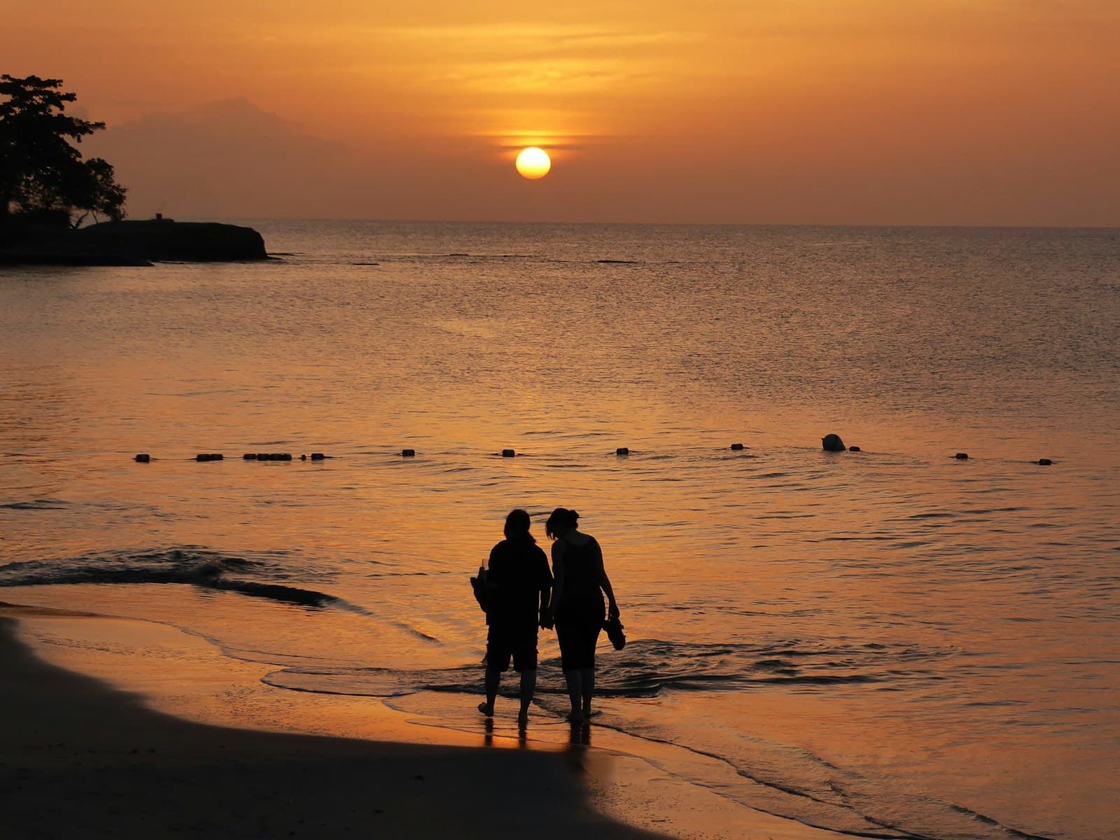 A couple walking at sunset on Halcyon Beach in Saint Lucia